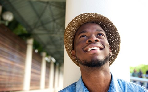 smiling man in a hat who has beautiful porcelain veneers