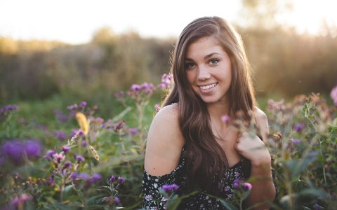 smiling girl standing among flowers