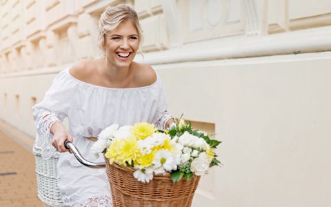 woman on a bike with flowers who has beautifully straightened teeth