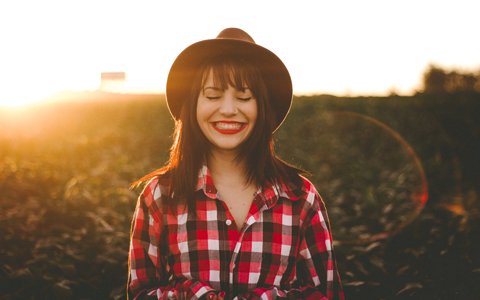 smiling woman in a hat who had a dental emergency in Huntington