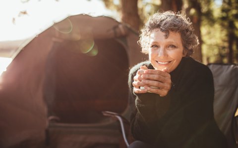 smiling woman drinking tea who had restorative dentistry near Centerport