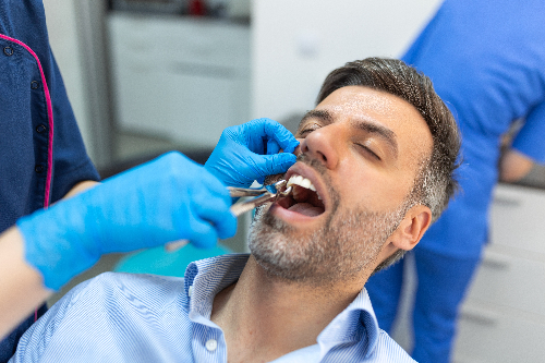 man having a tooth pulled in Huntington