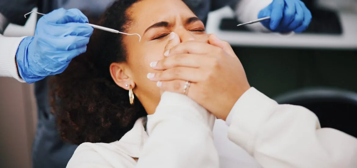 anxious dental patient covering her mouth with both hands