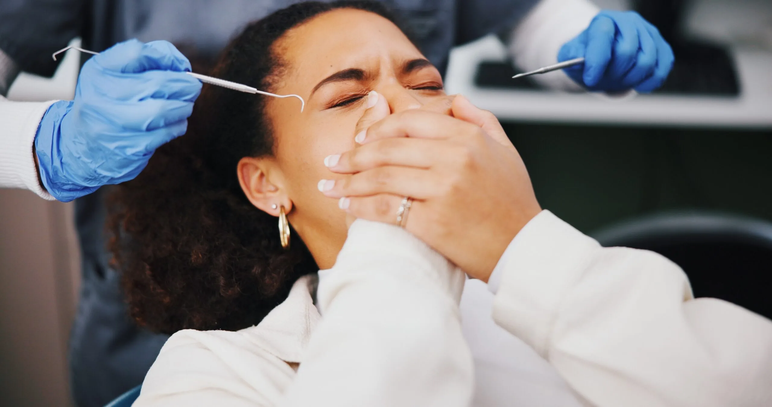 anxious dental patient covering her mouth with both hands