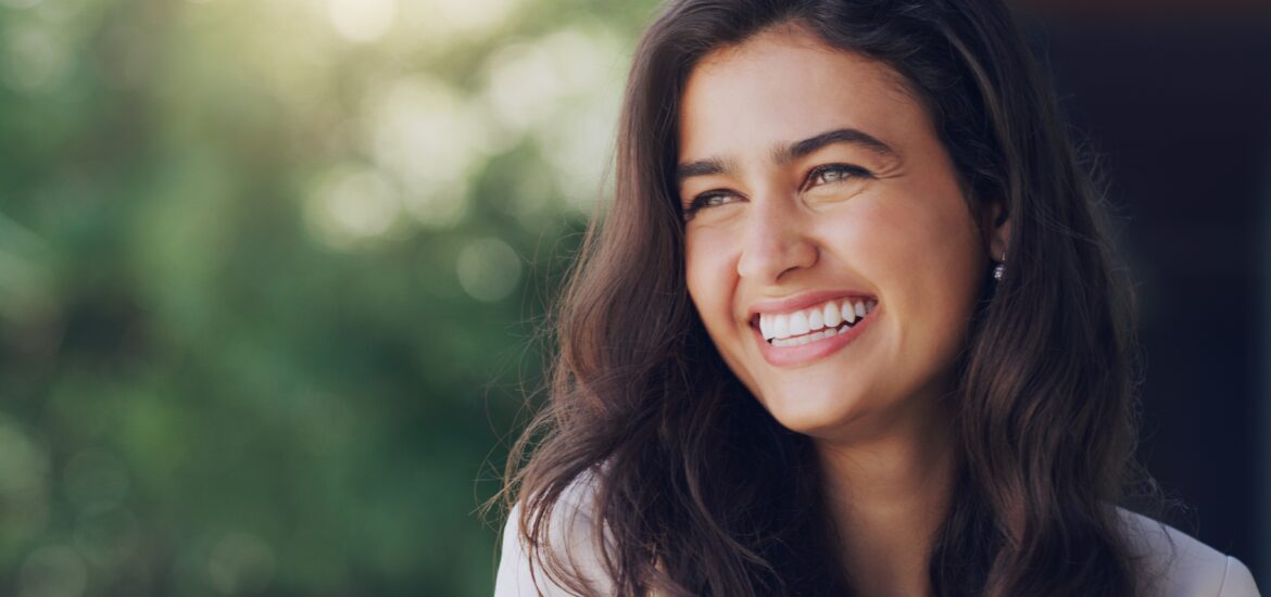 happy young woman smiling outdoors, perfect white teeth