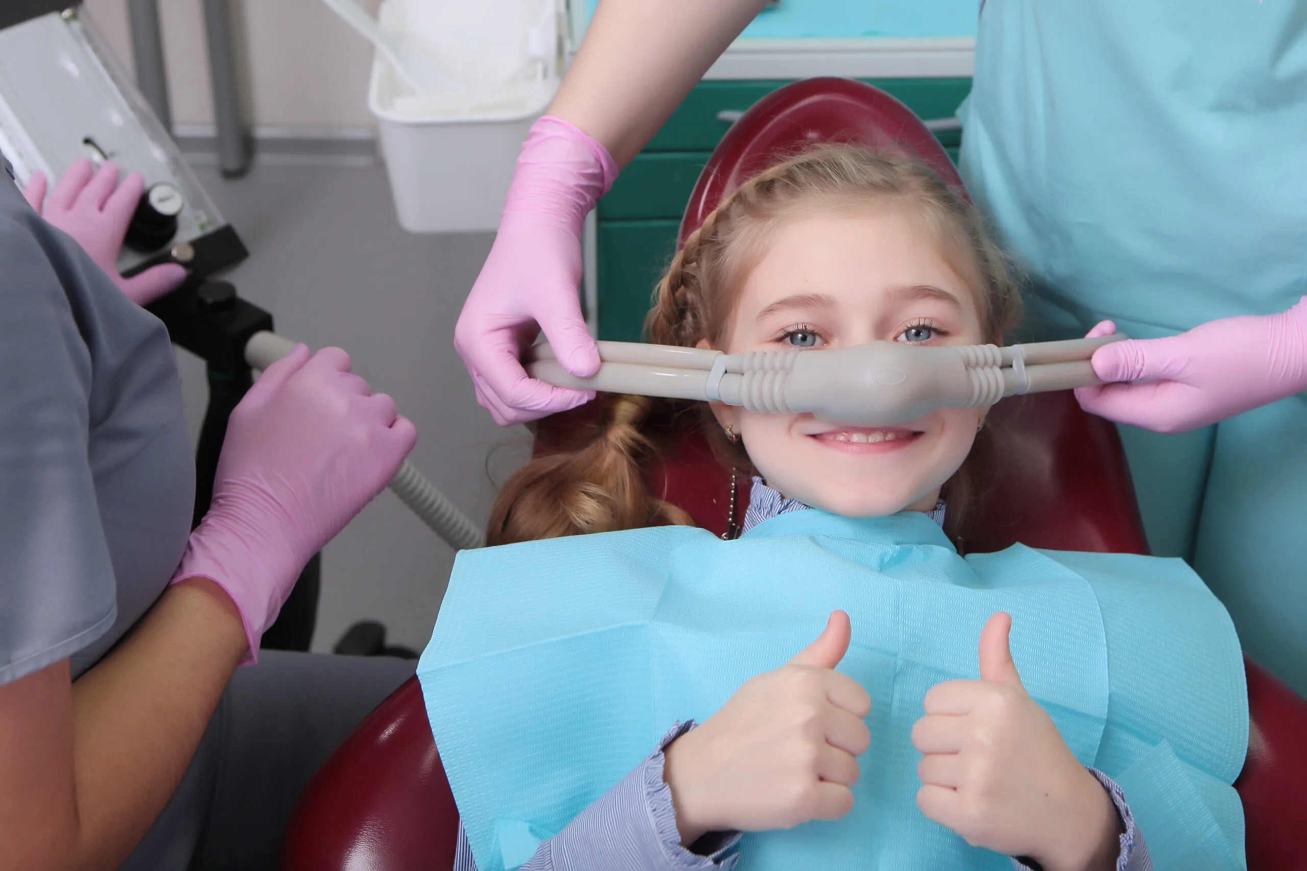 A little girl feels comfortable trying dental sedation, laughing gas