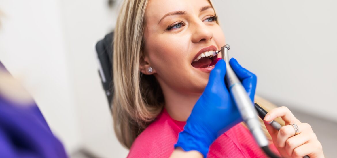 dentist in blue gloves polishing a dental crown